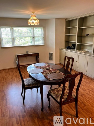 A dining room with a round table and chairs.