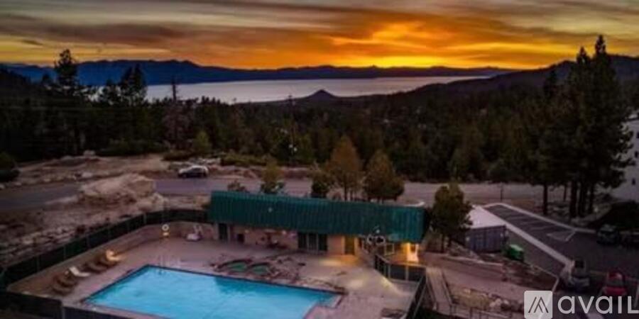 A beautiful sunset view of a pool and a house with a mountain in the background.