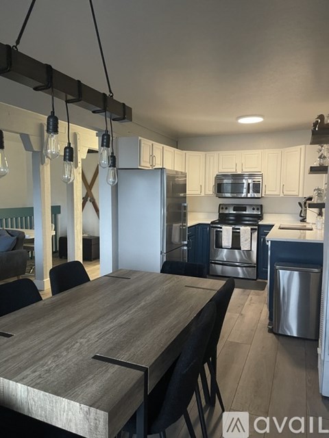 A kitchen with a wooden table and chairs.