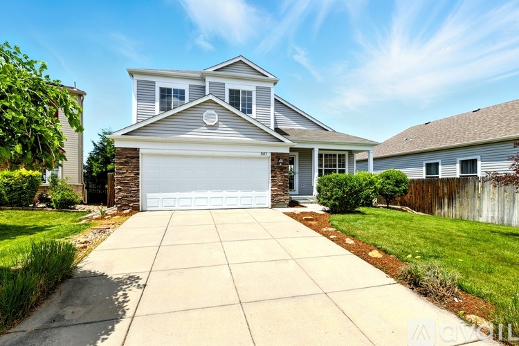 A two-story house with a garage and a driveway.