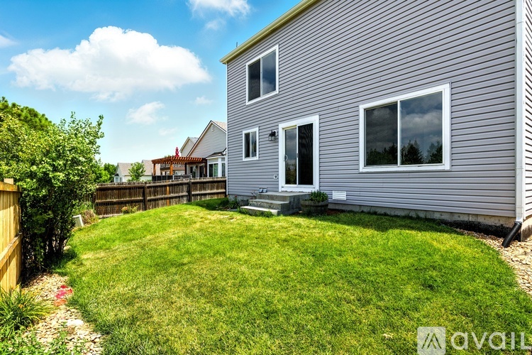 A house with a grey exterior and a green lawn.