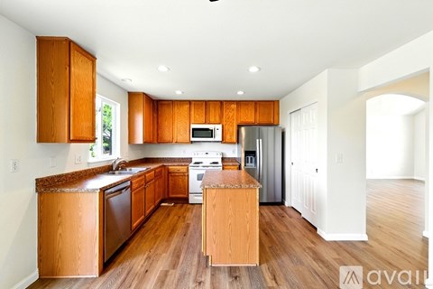 A kitchen with wooden cabinets and a white stove top oven.