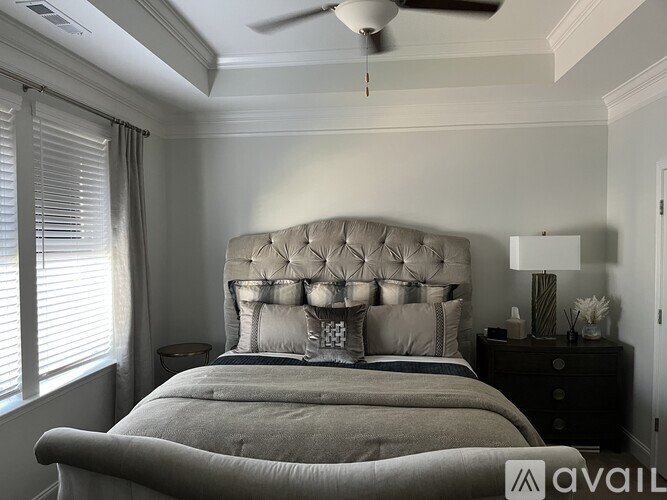A bedroom with a large bed and a ceiling fan.