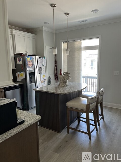 A kitchen with a refrigerator covered in magnets and a dining table with chairs.