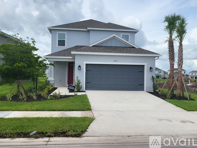 A two-story house with a garage and a driveway.