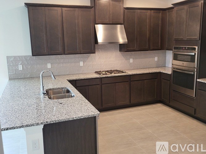 A kitchen with brown cabinets and a granite countertop.