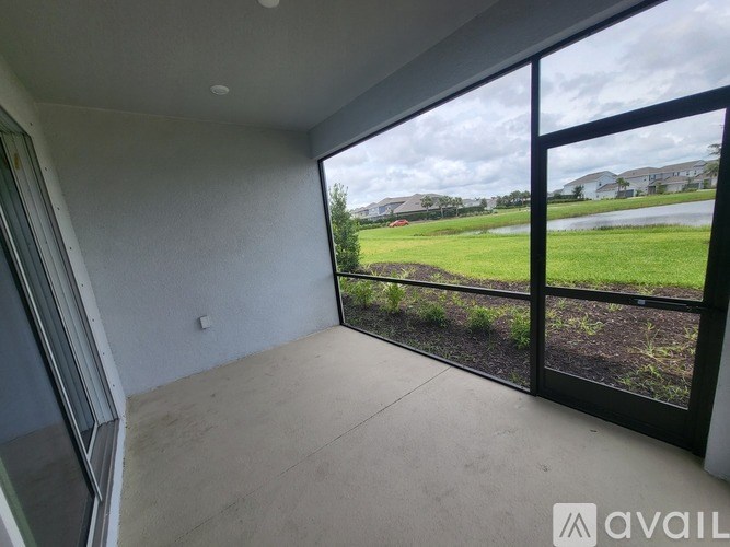A balcony with a view of a green lawn and houses.