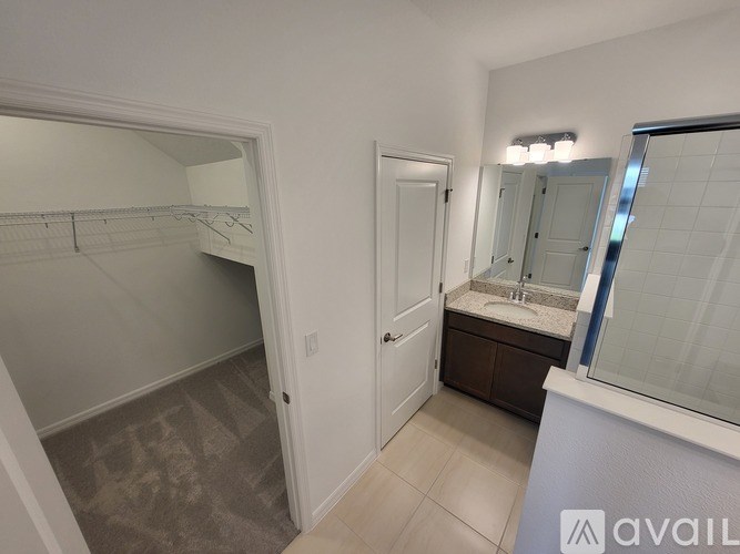 A bathroom with a sink, mirror, and a white door.