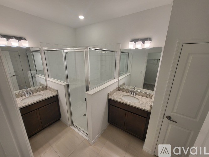 A bathroom with two sinks and a walk-in shower.