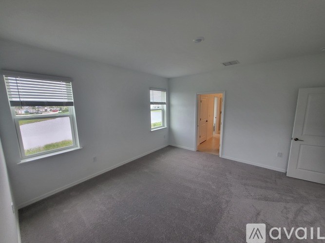 A spacious room with a door and two windows.