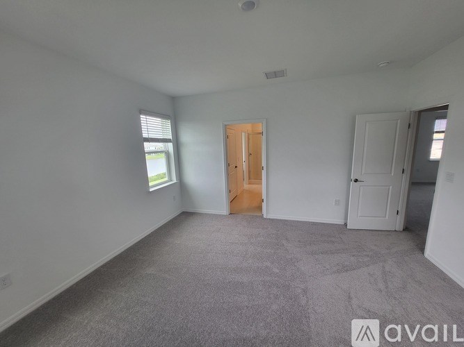 A room with a carpeted floor and a door in the middle.