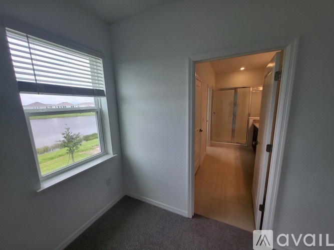 A room with a window and a door leading to another room.