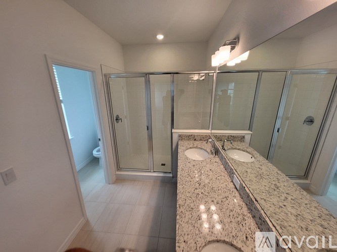 A bathroom with a marble countertop and a walk-in shower.
