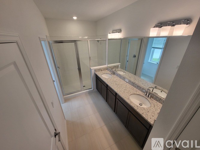 A bathroom with a sink, mirror, and shower.