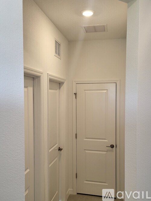 A hallway with two doors and a light on the ceiling.