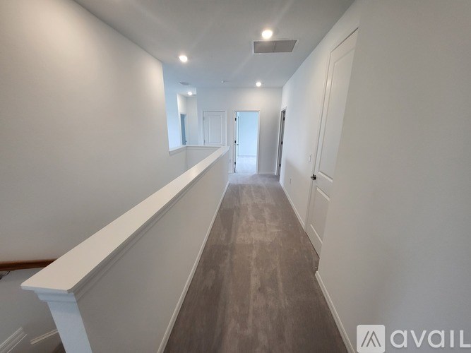 A long hallway with a white railing on the left side.