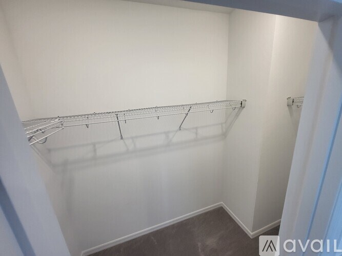 A white closet with a metal rack on the wall.