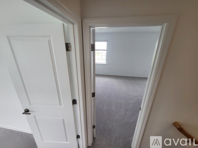 A white door is open to a room with a window.