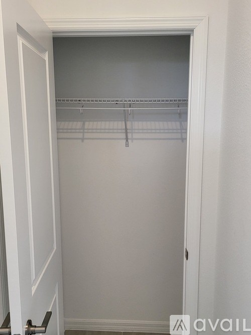 A white closet with shelves and hangers.