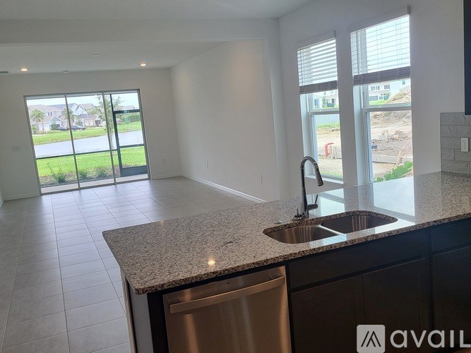 A kitchen with granite countertops and a stainless steel dishwasher.