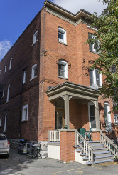 A red brick building with a white door and windows.