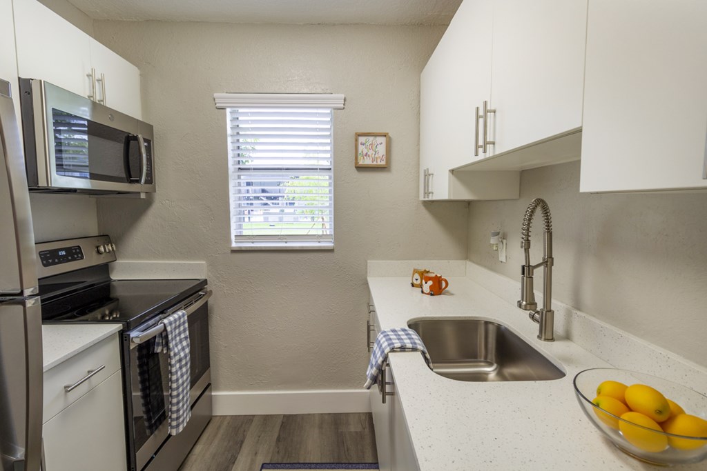 A kitchen with a stove, microwave, and oven.