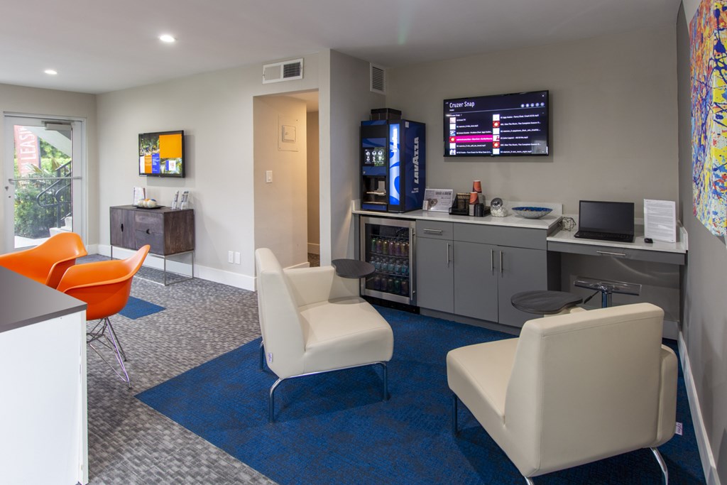 A room with a blue carpet and white chairs.