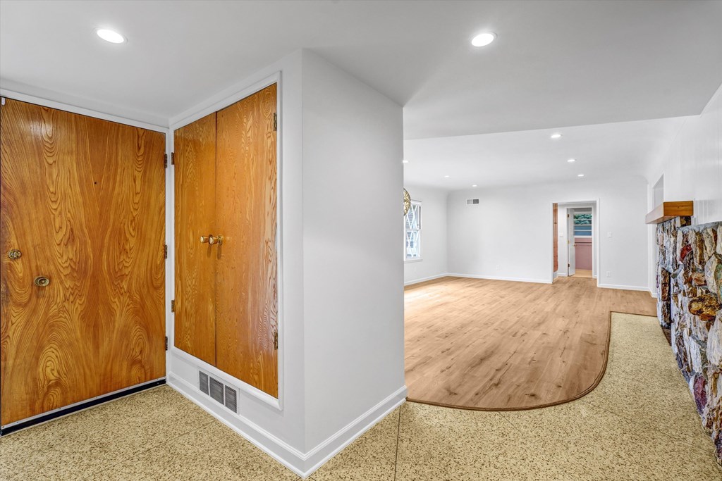 A room with a wooden floor and a wall with a door.