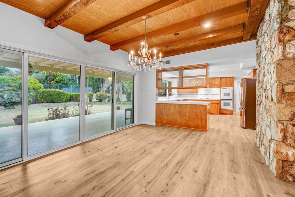 A spacious room with wooden floors and a stone wall.