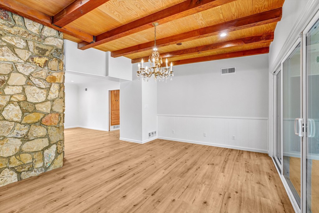 A room with wooden floors and a stone wall.