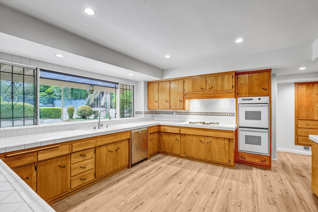 A kitchen with wooden cabinets and a white countertop.