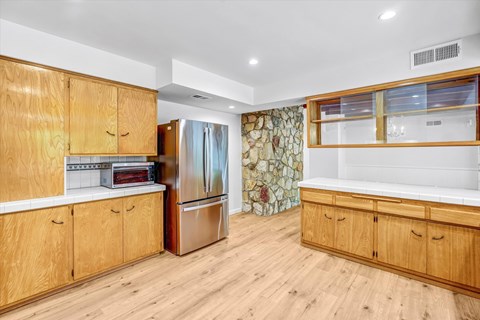 A kitchen with wooden cabinets and a refrigerator.