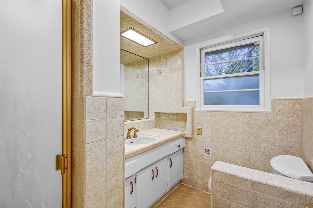 A bathroom with a window above the toilet.