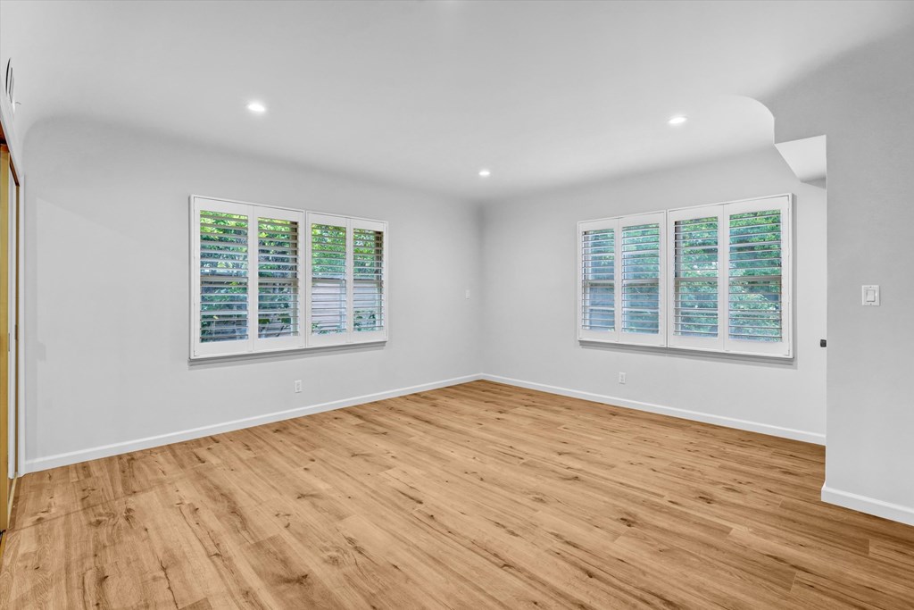 A room with wooden floors and two framed pictures on the wall.