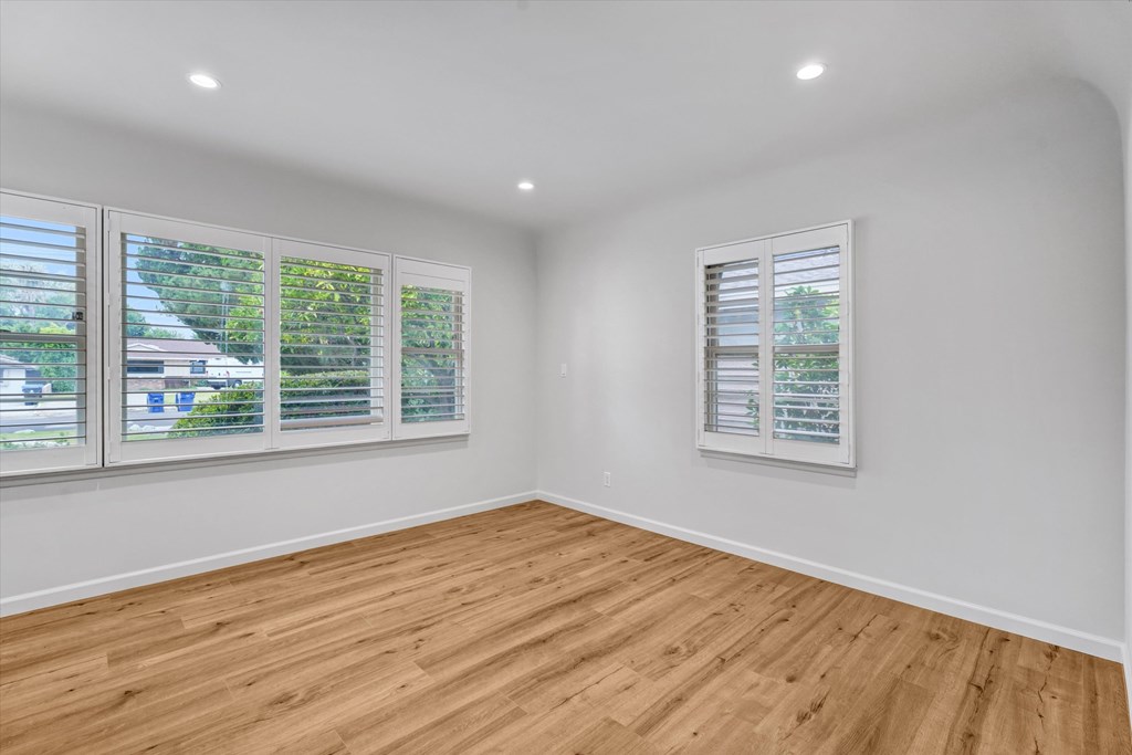 A room with wooden flooring and white walls.