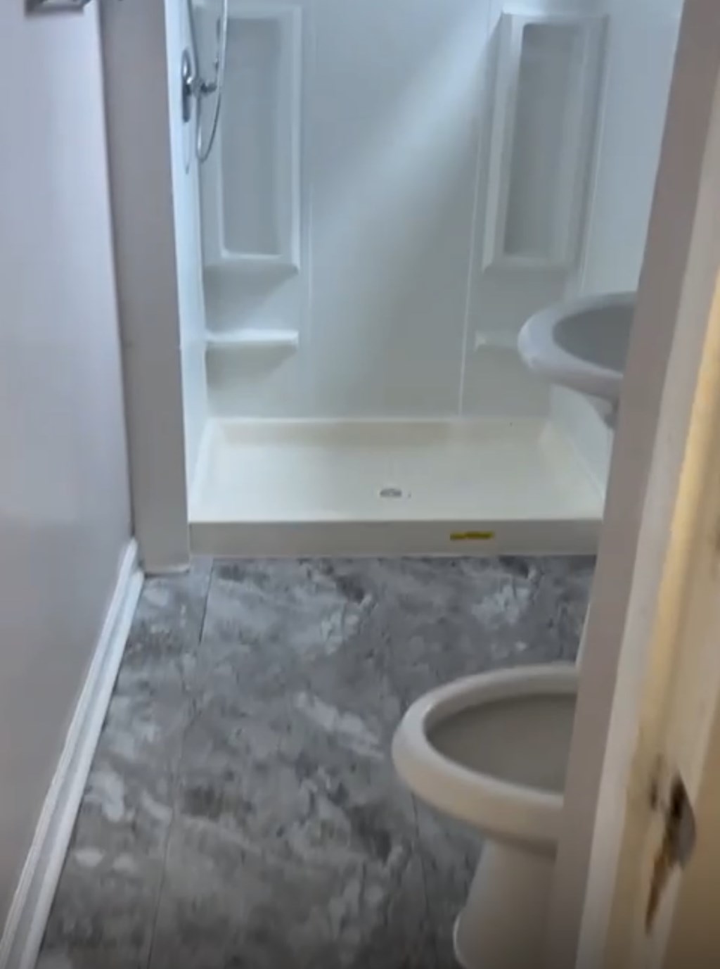 A white toilet in a bathroom with a walk-in shower.