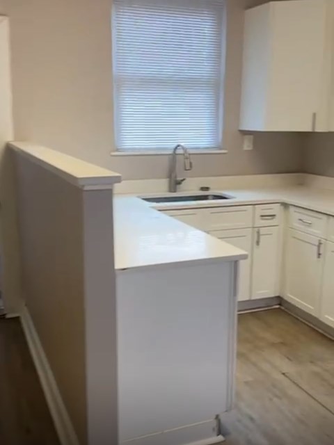 A kitchen with white cabinets and a white counter.