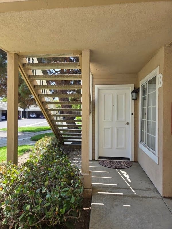 A white door is on the right and a staircase is on the left.