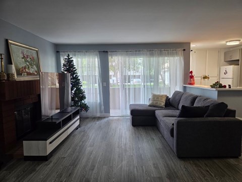 A living room with a grey couch and a fireplace.