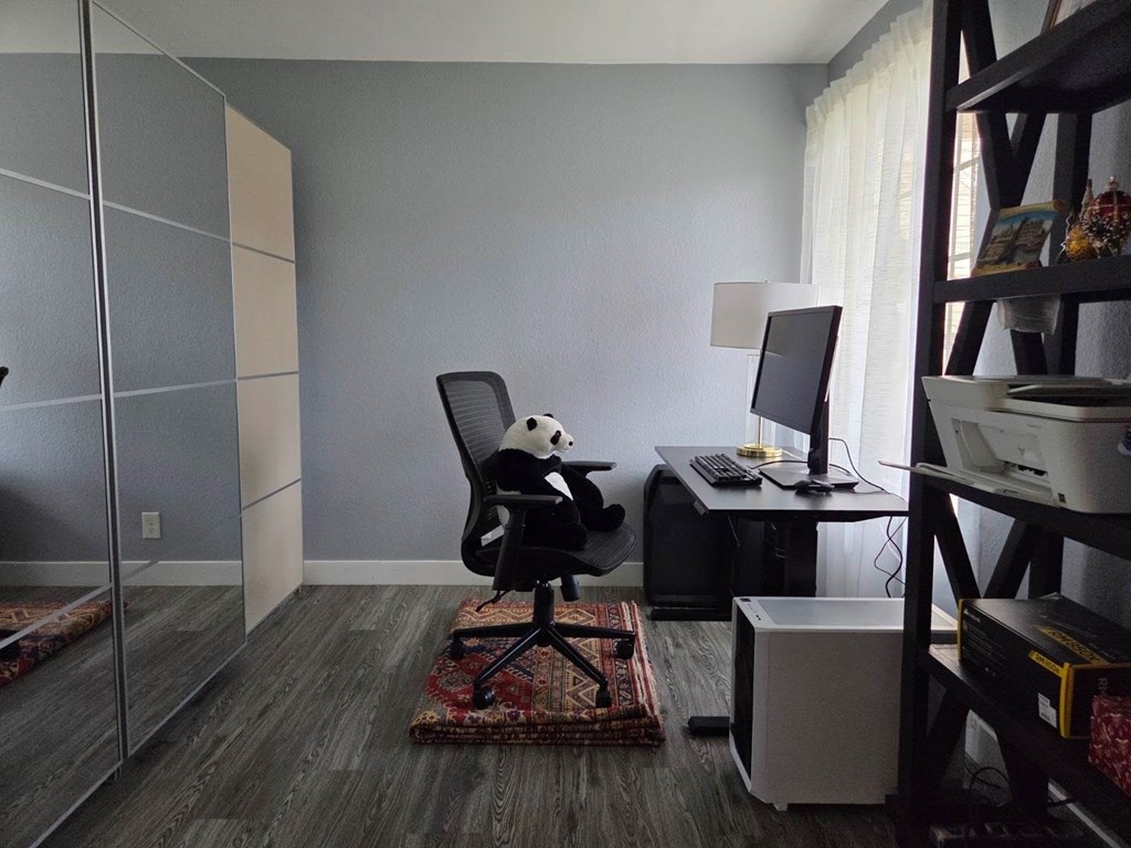 A room with a chair, desk, and computer.