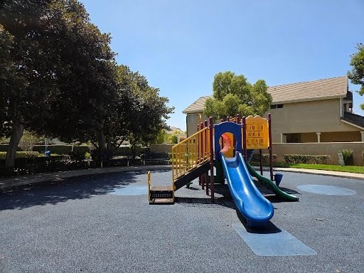 A playground with a blue slide and a yellow structure.