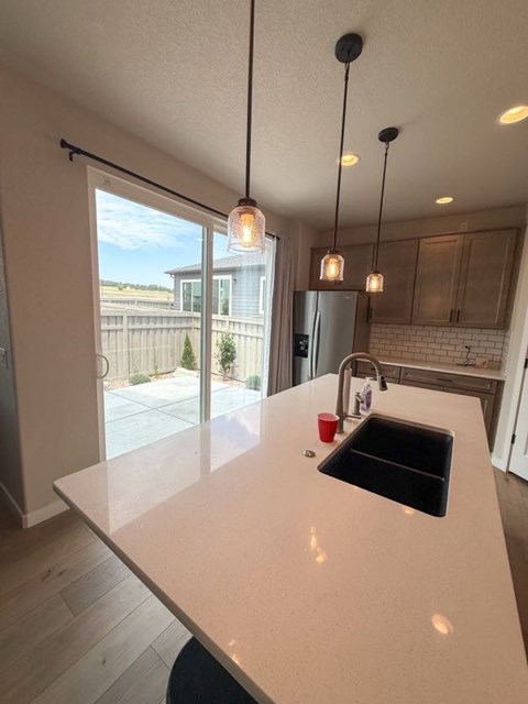 A kitchen with a white countertop and a black sink.