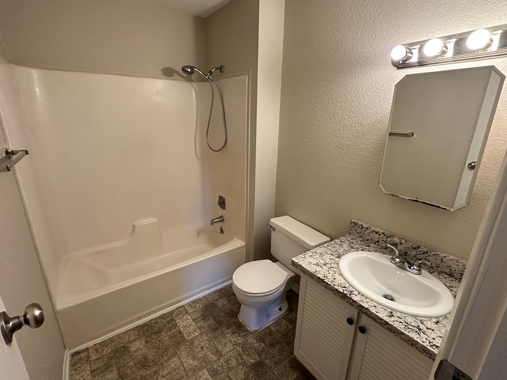 A bathroom with a toilet, sink, and shower.