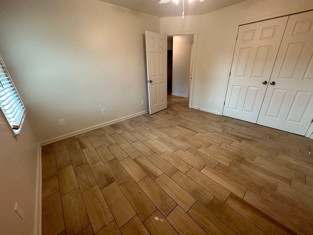 A room with wooden flooring and white doors.