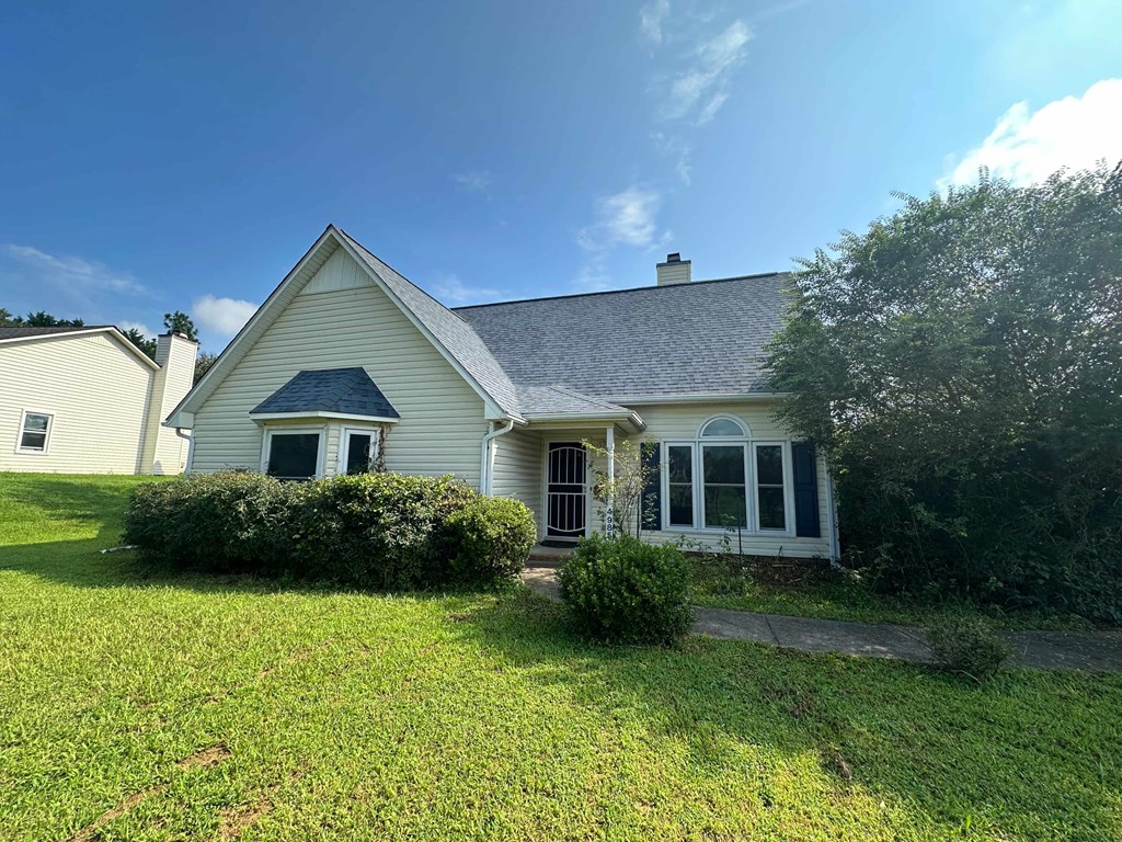 A small white house with a dark blue roof and a small porch.