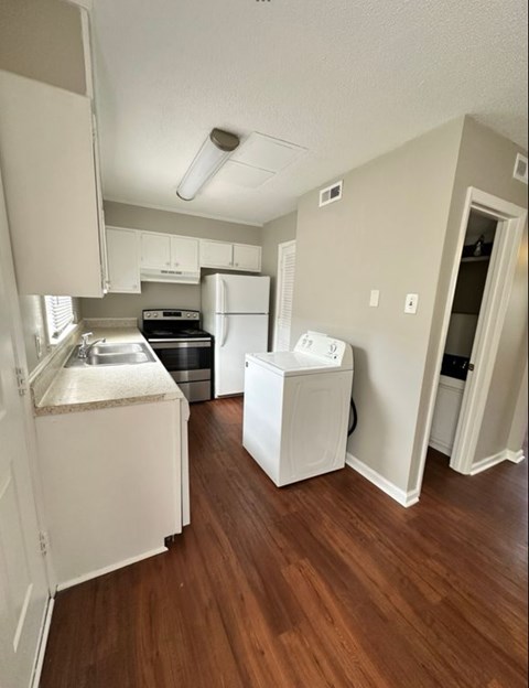 A small kitchen with a dishwasher and a washing machine.