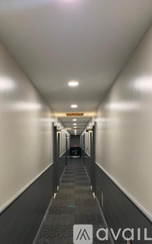 A long hallway with a person walking down it.