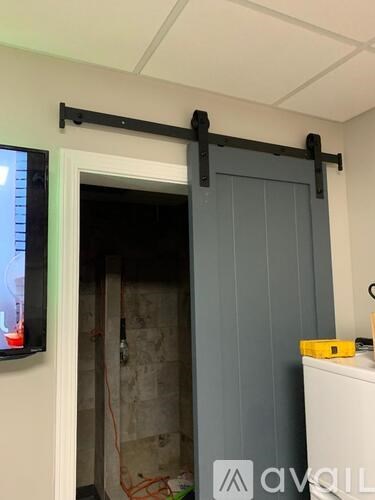 A door with a black bar across it is open.