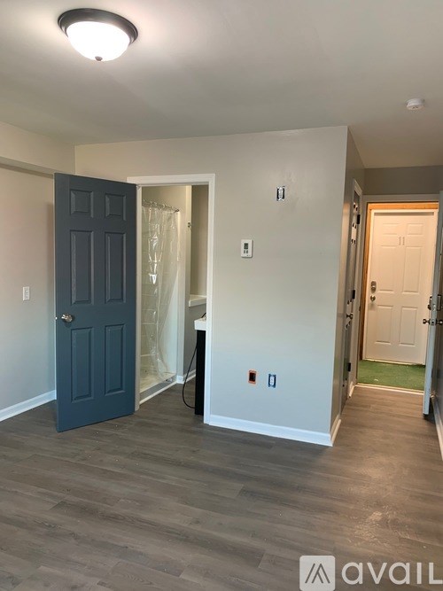 A room with a dark blue door and a white wall.