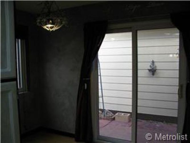 A room with a window and a chandelier.